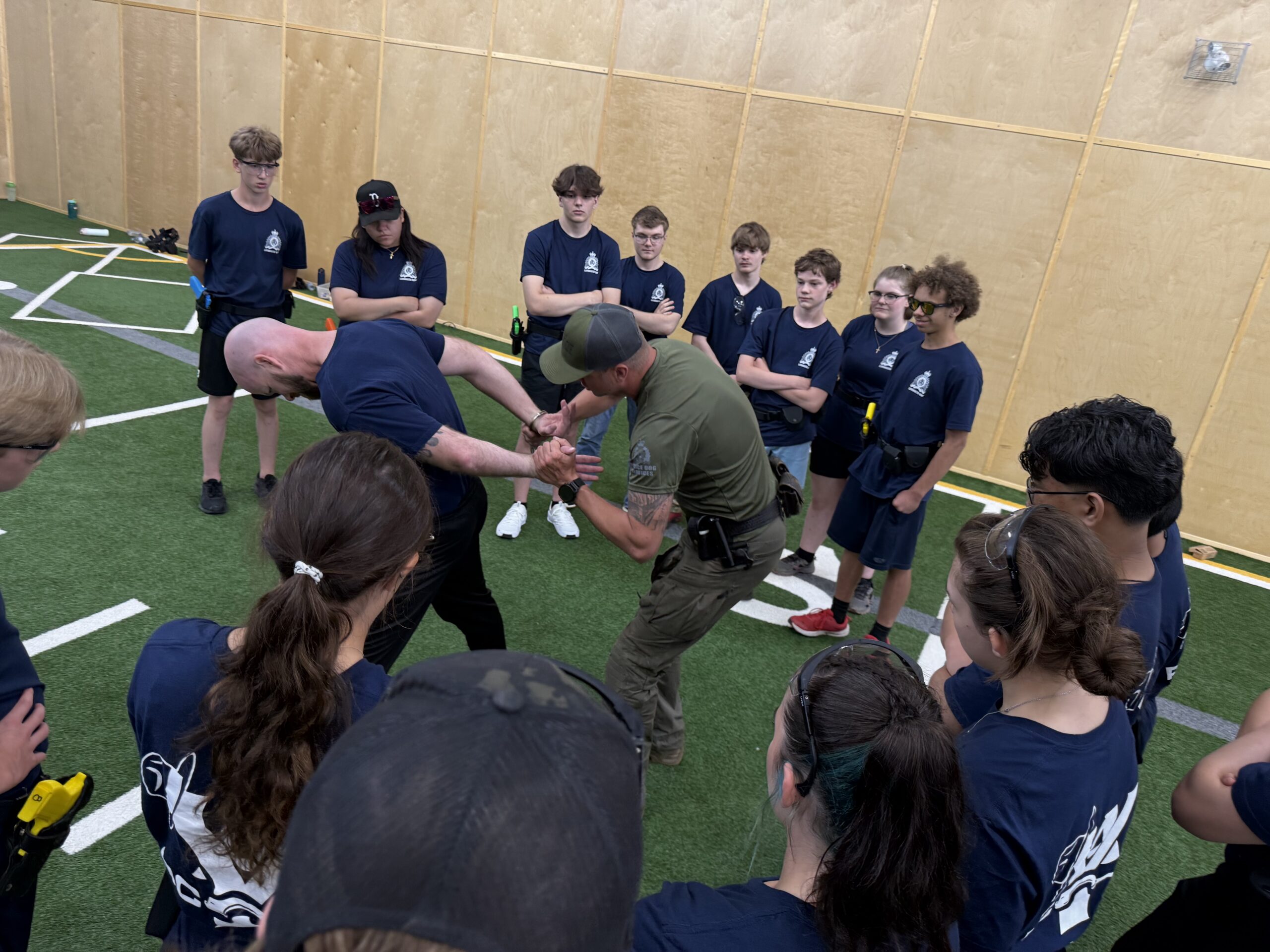 RCMP members show youth how to make and arrest.