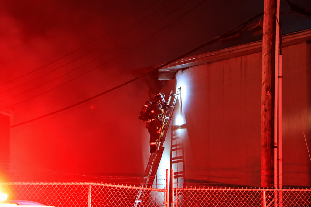 Firefighter on ladder in red glow