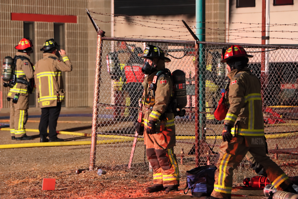 Firefighters Outside an Industrial Building at Night